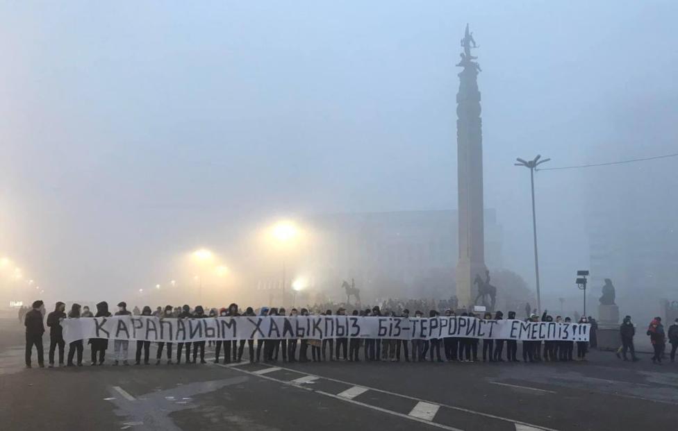 Протестующие держат плакат с надписью: "Мы люди, а не террористы" в Казахстане EYEPRESS via Reuters Connect