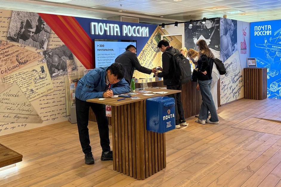 Иностранцы отправляют домой из "Манежа" открытки в честь 80-летия Победы ТАСС